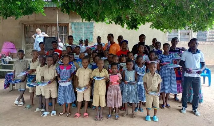 Les enfants heureux de recevoir des kits scolaires