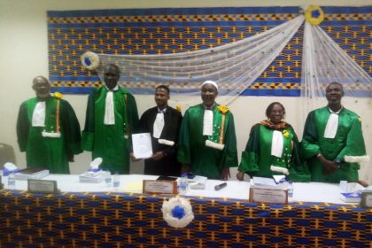 En toge noir, docteur DJE Monkoha Pacôme Kévin et les membres du jury