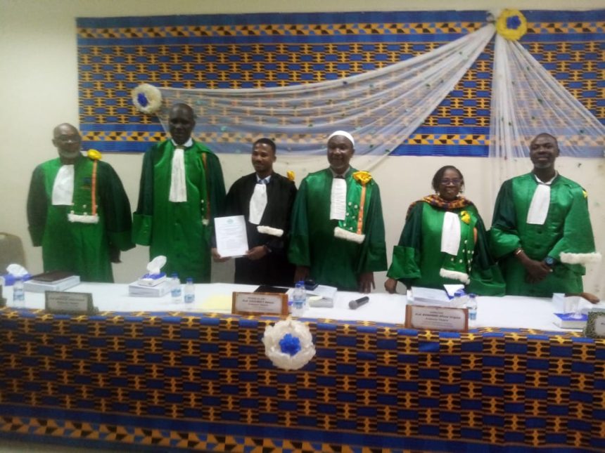 En toge noir, docteur DJE Monkoha Pacôme Kévin et les membres du jury