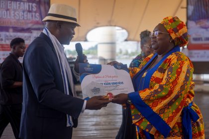 Turbuce Koffi remettant le prix de distinction à la présidente de l'Ong N'Klo BaKan, Dagry Geneviève