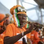 Un supporter ivoirien en orange souffle dans une corne à la cérémonie d’ouverture de la CAN 2023