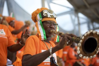 Un supporter ivoirien en orange souffle dans une corne à la cérémonie d’ouverture de la CAN 2023